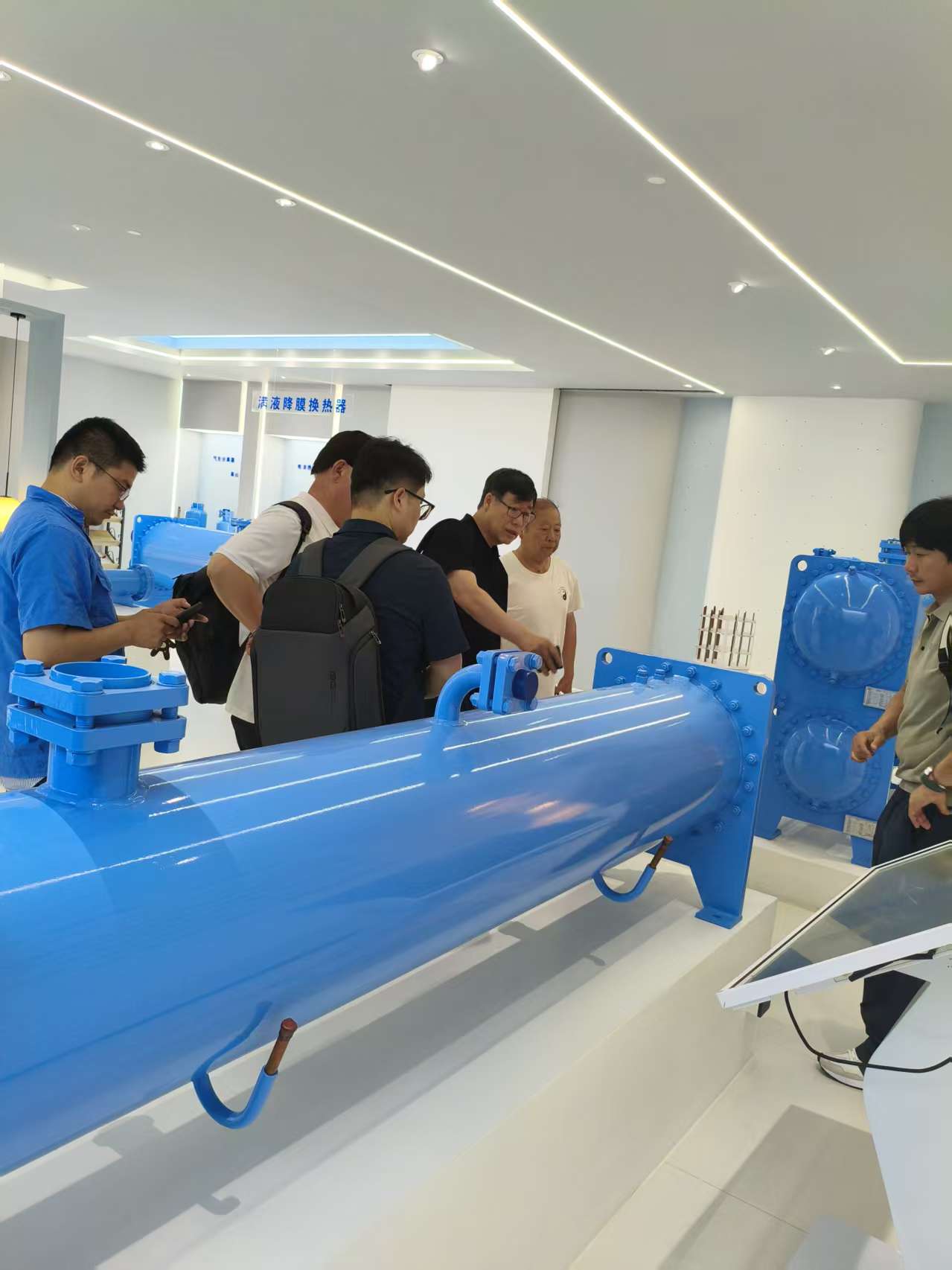 Visitors reviewing the falling-film heat exchanger product series
