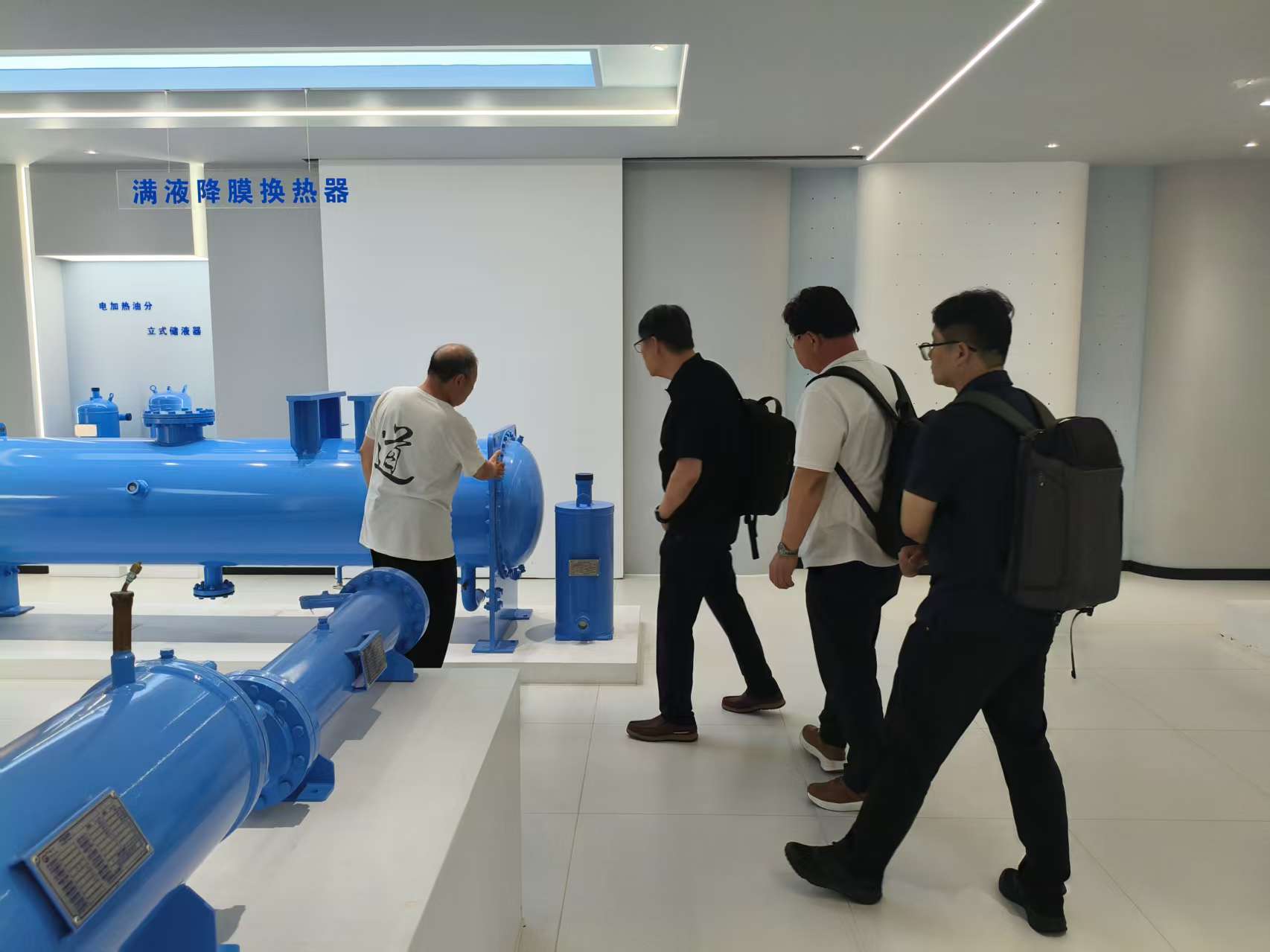 HI AIR delegation examining a flooded heat exchanger in the honryheatex showroom